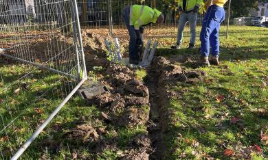 Trois personnes devant le socle d'une structure