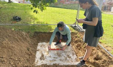 Deux personnes prennent des mesures sur le sol